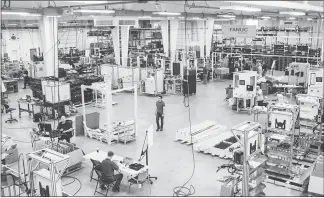  ??  ?? Employees work on the production floor at APT Manufactur­ing Solutions.