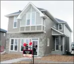  ??  ?? Above, the exterior of the Kennedy model by Trico Homes, one of 21 show homes that recently opened in Evanston. Left, an elegant and functional two-sided fireplace connects the master bedroom with the ensuite.