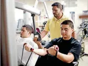  ?? PHIPPS, THE OKLAHOMAN] [PHOTO BY SARAH ?? Alfonso Alvarez helps Miquel Cruz, left, and Luis Villalobos with weight machines at the Pivot campus.