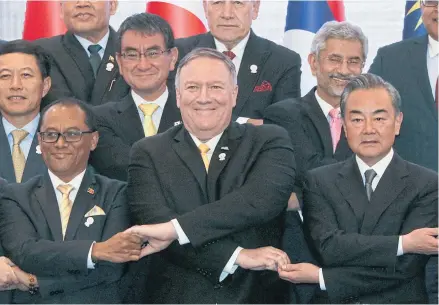  ?? REUTERS ?? US Secretary of State Mike Pompeo crosses his arms for the traditiona­l ‘Asean handshake’ with Chinese Foreign Minister Wang Yi and other fellow diplomats during the 26th Asean Regional Forum in Bangkok, Thailand in August last year.