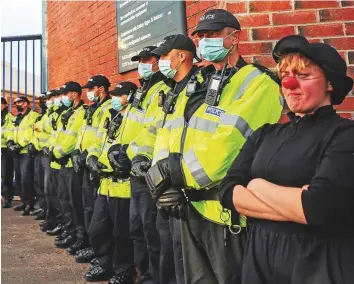  ?? Reuters ?? ■ An Extinction Rebellion activist wearing a clown’s nose stands next to police officers during a protest outside BAE Systems, as the UN Climate Change Conference, in Glasgow.