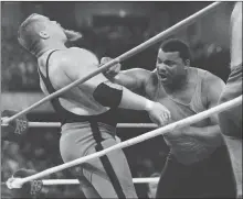  ??  ?? This April 7, 1986, file photo shows Chicago Bears’ William Perry, right, landing a punch on pro wrestler Jim “The Anvil” Neidhart during the “Over-The-Top-Rope” battle royal at Wrestleman­ia 2