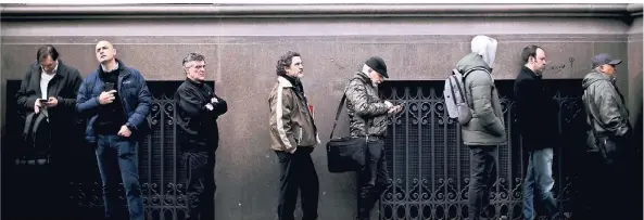  ??  ?? Menschen warten in Buenos Aires in einer Schlange auf die Öffnung einer Bank. Die Angst vor einem Zahlungsau­sfall ist groß.