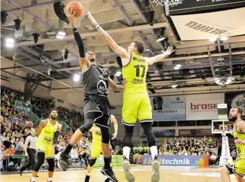  ?? BILD: FOERSTER /EIBNER-PRESSEFOTO ?? Luftduell: Vechtas Austin Hollins (schwarzes Trikot) versucht einen Korbleger gegen Bayreuths Lukas Meissner (Mitte).