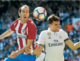  ??  ?? Diego Godín, del Atlético de Madrid, disputa un balón con el jugador de Real Madrid, Pepe, en un partido por la liga española ayer en Madrid.