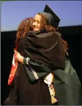  ??  ?? Graduate Brooklyn Young gets a hug after accepting her diploma.