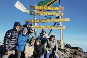  ?? Colleen Thomas/TNS ?? Members of the Ballard and Thomas families gather for a group photo at the top of Africa’s Mount Kilimanjar­o. The climb up the continent’s highest mountain was a seven-day trek.