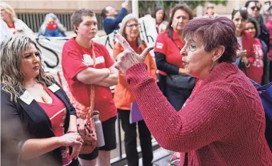  ?? PHOTOS BY ANTRANIK TAVITIAN/THE REPUBLIC ?? Kelley Fisher, right, a teacher in the Deer Valley School District, leads a chant on Wednesday outside the Arizona Department of Education building in Phoenix to protest a new complaint hotline.