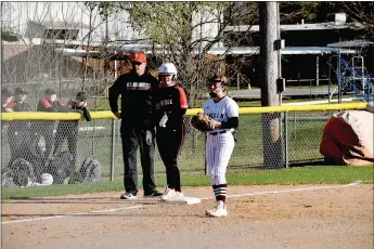  ?? Mark Humphrey/Enterprise-Leader ?? Pea Ridge head softball coach Josh Reynolds confers with junior Callie Cooper stationed at third behind Lincoln infielder Amber Bryant. Pea Ridge defeated Lincoln, 10-0, in a run-rule shortened nonconfere­nce softball game that lasted five innings on Tuesday, March 14.