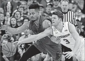  ?? [ANDY MANIS/THE ASSOCIATED PRESS] ?? Maryland’s Melo Trimble, left, and Wisconsin’s Zak Showalter go after the ball during the second half Sunday in Madison, Wis.
MINNESOTA 83, MICHIGAN 78, OT: Michigan State’s Harris out with season-ending knee injury: