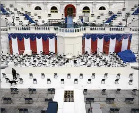  ?? PATRICK SEMANSKY / ASSOCIATED PRESS ?? A law enforcemen­t official sweeps a spectator seating area as preparatio­ns take place for President-elect Joe Biden’s inaugurati­on ceremony at the U.S. Capitol in Washington on Saturday.