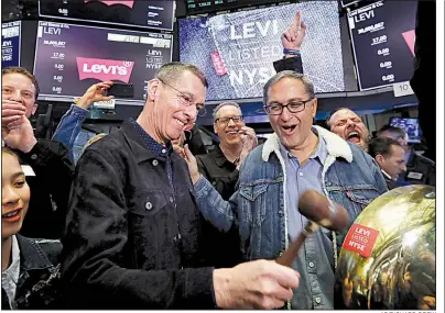  ?? AP/RICHARD DREW ?? Levi Strauss Chief Executive Officer Chip Bergh (left) is joined by Chief Financial Officer Harmit Singh as he rings a ceremonial bell Thursday when his company’s initial public offering begins trading on the New York Stock Exchange. Video at arkansason­line.com/322levi/