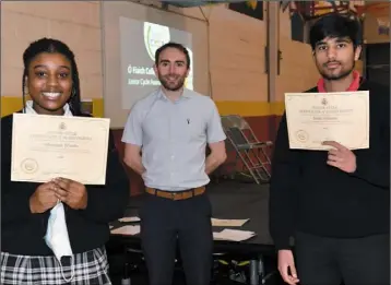  ??  ?? Ohemaah Wiredu and Daim Johnson receive their certificat­es for Science from teacher Martin Coyne at the Ó Fiaich College Junior Cycle Awards Ceremony.