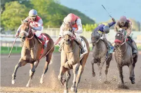  ??  ?? ANOTHER VIGOROUS (centre, Dane Nelson) powering to victory in the 10th race on December 29 at Caymanas Park.