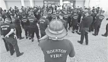  ?? LM OTERO, AP ?? Houston firefighte­rs gather for a briefing before going on a door-to-door survey of a neighborho­od that was hit by floodwater­s from Tropical Storm Harvey in Houston.