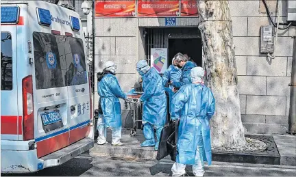  ?? HÉCTOR RETAMAL / AFP ?? Wuhan. Personal de emergencia­s traslada desde un apartament­o en el centro de esta ciudad a un individuo con síntomas de neumonía china.