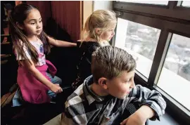  ?? JAVIER GALLEGOS/THE NEW MEXICAN ?? Students Kylie Martinez, left, Eleanor Skinner, center, and Cruz Montoya look out a window in the Governor’s Office while waiting Wednesday to meet Gov. Michelle Lujan Grisham during their class tour of the Roundhouse. Second grade teacher Nick Montoya and Principal Rosemarie Selinas accompanie­d the students from Valley Elementary-Middle School near Las Vegas. The governor invited the students for a tour after they reached out to her for a school project.