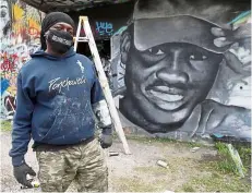  ?? —AP ?? never forget: Artist Theo Ponchaveli standing in front of a mural he painted in the likeness of Arbery in Dallas.