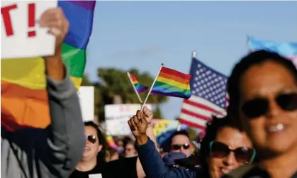  ?? Photograph: Martha Asencio-Rhine/AP ?? Marchers wave US and rainbow flags and signs as they march in St Petersburg, Florida, in March 2022 to protest the controvers­ial ‘don't say gay’ bill.