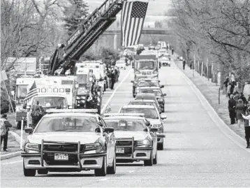  ?? MICHAEL CIAGLO/GETTY ?? Law enforcemen­t vehicles escort the hearse carrying the body of slain Officer Eric Talley on Wednesday.