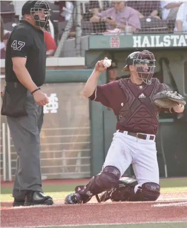  ?? (Photo by Jason Cleveland, SDN) ?? Mississipp­i State catcher Josh Lovelady, right, prepares to throw the baseball.