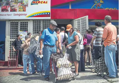  ?? Ronaldo schemidt/afp ?? El racionamie­nto se profundiza en la venta de comida, en Caracas