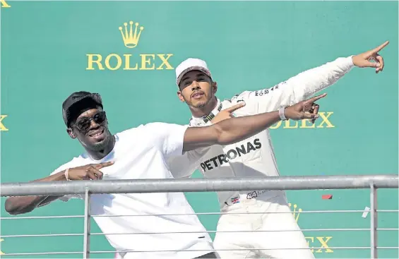  ?? DPA ?? Puro show. En el podio, Lewis Hamilton imita al jamaiquino Usain Bolt con su clásico festejo, patentado tras tantas victorias sobre la pista.