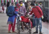  ?? — PTI ?? A child with physical disability is escorted on a wheelchair by family members at Howrah station in Kolkata on Monday.