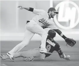  ?? RAY CHAVEZ/STAFF ?? The Marlins’ Dee Gordon steals second base as the A’s Jed Lowrie goes for the ball in the first inning. The A’s lost to the Marlins 11-9 on Tuesday at the Oakland Coliseum.