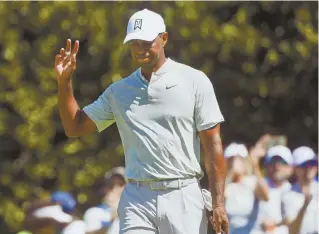  ?? AP PHOTO ?? HALFWAY HOME: Tiger Woods waves to the crowd during yesterday’s second round of the Tour Championsh­ip. Woods shares the lead with Justin Rose.