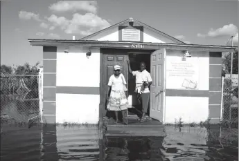  ?? (Reuters photo) ?? A couple in front of their church, Haitian United Evangelica­l Mission, which was damaged by flooding from Hurricane Irma in Immokalee, Florida, U.S. September 12