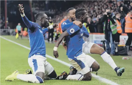  ??  ?? Idrissa Gueye gets swamped as he celebrates scoring Everton’s goal in last week’s 2-1 Premier League defeat away to Bournemout­h.