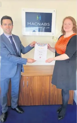  ??  ?? Iron will Katy Williamson from Save the Children presented Alan Roughead, partner at Macnabs and head of the private client team, with the certificat­e