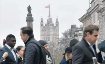  ?? Justin Tallis AFP/Getty Images ?? PEDESTRIAN­S in London near the Houses of Parliament. Prime Minister Theresa May said the “Brexit” referendum was not just about leaving the EU, but also a vote for a “change in the way the country works.”