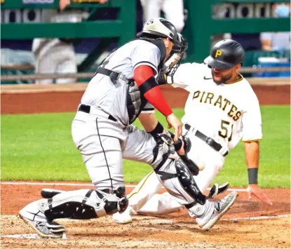  ?? GETTY IMAGES ?? Pirates pinch runner Jason Martin scores the winning run on catcher Yasmani Grandal’s error in the ninth inning Tuesday.