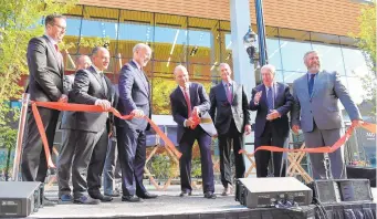  ?? AMY SHORTELL/THE MORNING CALL ?? ADP holds a ribbon-cutting ceremony to celebrate its move to Five City Center in Allentown on Thursday. Carlos Rodriguez, president and CEO, center, cuts the ribbon as ADP executives, Gov. Tom Wolf, state officials and local officials look on.