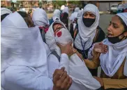  ??  ?? A Kashmiri schoolgirl is wounded after being hit by a stone during a protest in Srinagar Thursday.