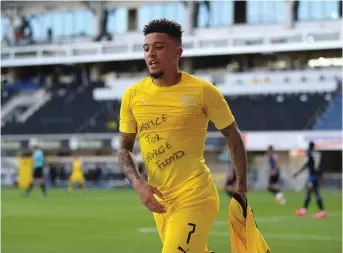  ??  ?? Borussia Dortmund midfielder Jadon Sancho shows a “Justice for George Floyd” shirt as he celebrates after scoring his team’s second goal against SC Paderborn during their Bundesliga match in Paderborn on Sunday. Dortmund won 6-1. — AFP