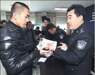  ?? ZHU WUTAO / FOR CHINA DAILY ?? Police officers in Linyi, Shandong province, help migrant workers get payment that had been withheld by their employers last month.