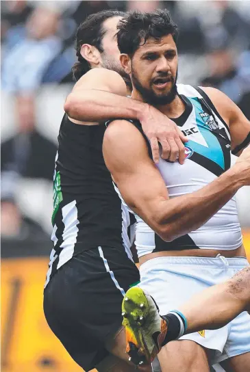  ??  ?? Collingwoo­d’s Brodie Grundy takes on the Port Adelaide’s Paddy Ryder (centre) and Robbie Gray in the Round 14 AFL match yesterday at the MCG