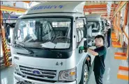  ?? TAN YUNFENG / FOR CHINA DAILY ?? Workers assemble electric vehicles at a new energy vehicle factory in Zhejiang province.