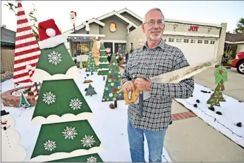  ?? Dan Watson/For the Signal ?? Bob Dodge stands with his display of unique hand-made Christmas trees entitled the “Land of Misfit Trees” in Bob’s front yard.