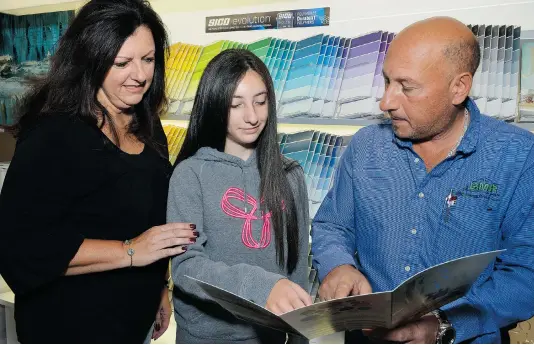  ?? - Ed Goodfellow: Special to The Star ?? Rita Bonitatibu­s helps daughter Amanda picks out new colours for her roomwith help from her husband Enzo, BMR Windsor Building Centre’s general manager. Clockwise below: selection of laminate flooring, corner shower stall and Sico colour paint charts...