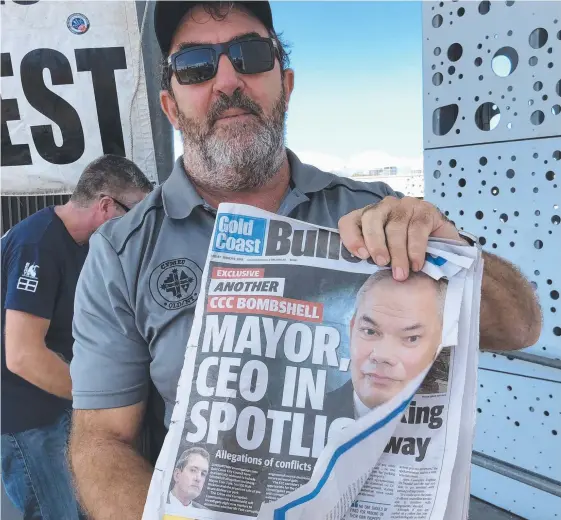 ??  ?? Union leader Paul Taylor with a copy of last Friday's Gold Coast Bulletin at a council worker protest at the Broadwater Parklands, Southport, yesterday.
