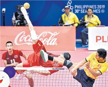  ??  ?? A Thai player spikes the ball against Vietnam in the men’s sepak takraw regu event yesterday.
