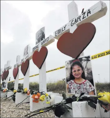  ?? David J. Phillip The Associated Press ?? Crosses show victims’ names near the First Baptist Church in Sutherland Springs, Texas, on Thursday. A gunman killed more than two dozen people inside the church last week.