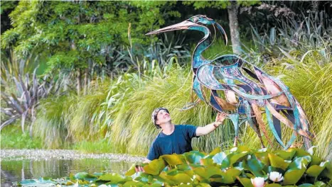  ?? ?? Hawke’s Bay artist Glen Colechin with his sculpture Serenity, a kōtuku (white heron) sitting on water on lily pads, which won the 2021-22 Friends People’s Choice Award at the Sculpture in the Gardens, in Auckland.