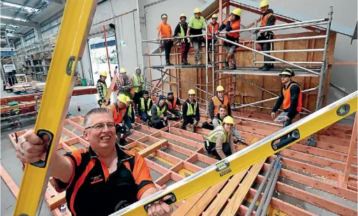  ?? MARTIN DE RUYTER/ THE LEADER ?? Murray Leaning of Mitre 10 Mega with Nelson Marlboroug­h Institute of Technology pretrade carpentry course students working on the new trade display area.