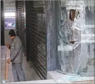  ?? (AFP) ?? A man cleans the branch of a local bank that was vandalised the previous night by anti-government protesters in the Lebanese capital Beirut, on Wednesday.