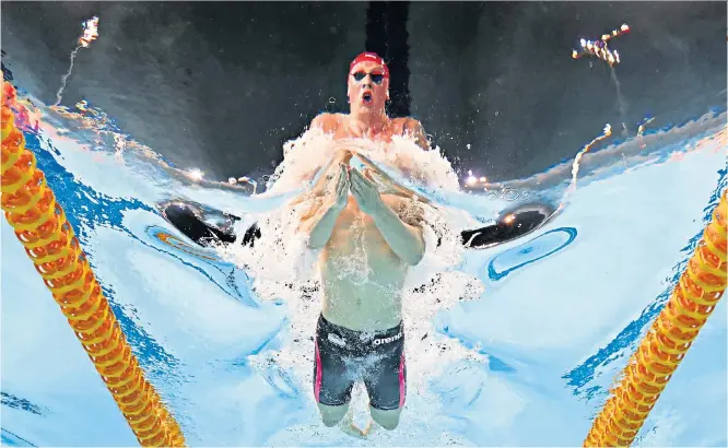  ??  ?? Unparallel­led: Adam Peaty on his way to winning gold in the 100m breaststro­ke at the Gold Coast Aquatics Centre and (below) acknowledg­ing the acclaim at the medal ceremony